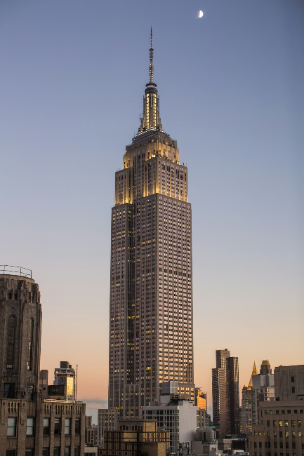 Tall skyscraper with a half moon in the sky