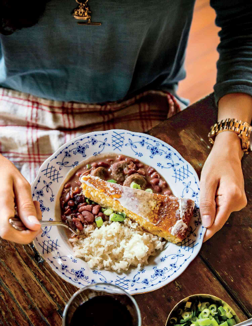 Bowl of red beans and rice with a slice of cornbread on top