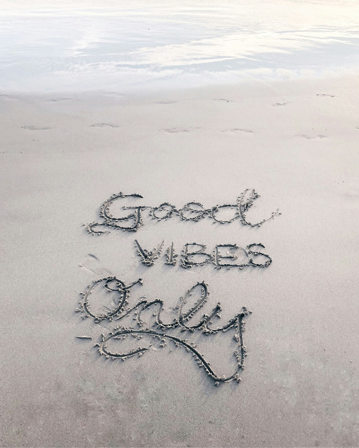 Good vibes only written in sand on a beach