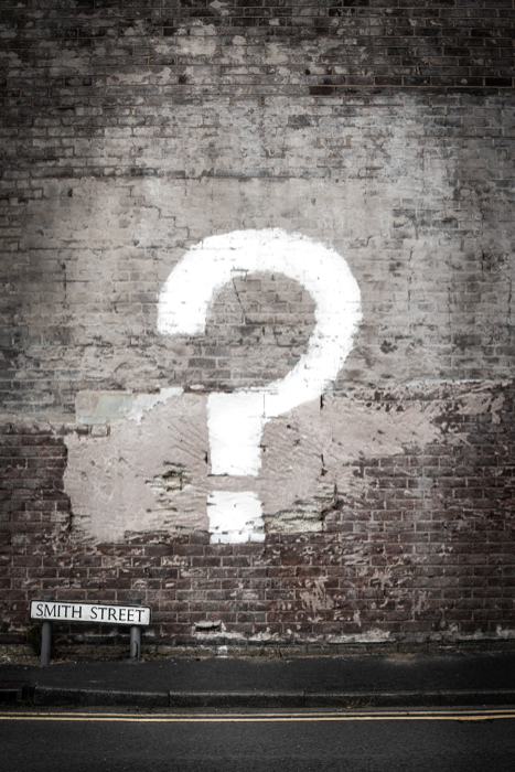 Giant question mark painted on a brick wall