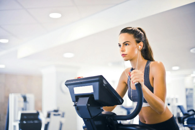 Woman on a treadmill wearing ear plugs