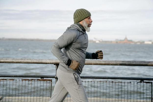 Middle-aged man jogging along the river boardwalk