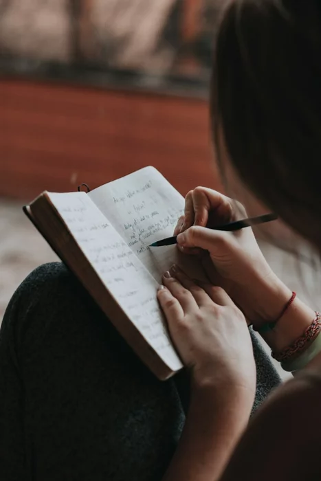 A person writing in a weight loss journal