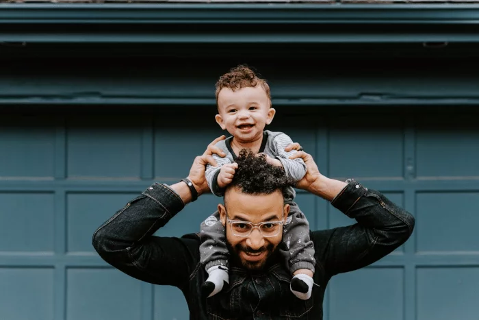 A fit dad with his son on his shoulders.